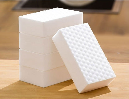 Stack of white melamine foam cleaning sponges with textured surface